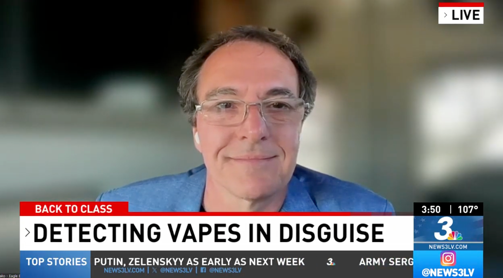 News anchor with glasses in a blue blazer on a live broadcast; main headline reads Detecting Vapes in Disguise.