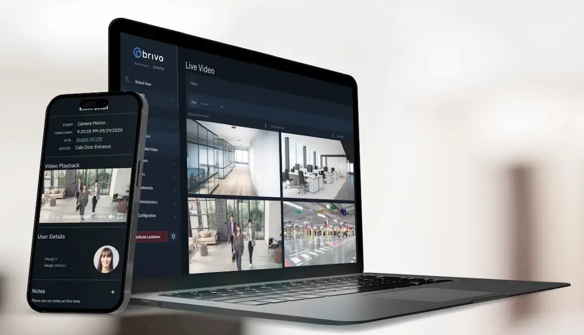 Laptop and smartphone displaying a security camera dashboard with four live feeds of an office lobby.
