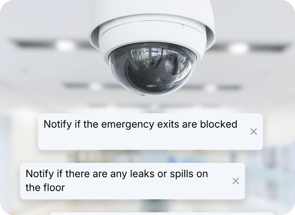 Dome security camera on ceiling with two on-screen alert banners: blocked exits and floor leaks.