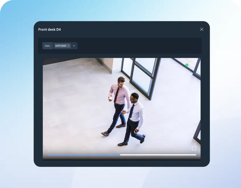 Screenshot of a front desk software interface labeled 'Front desk D4' showing a video player with two casually dressed men in shirts and ties walking in a bright office lobby windowed area.